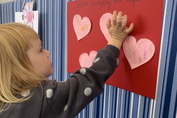 Krasnale kolorują papierowe serca na znak koleżeństw